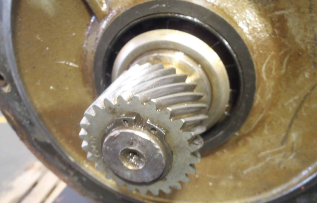 Describes a helical gear held by a snap ring on an electric motor  shaft